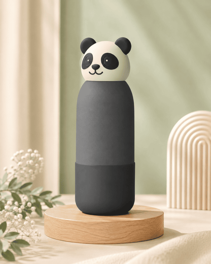A cute panda-shaped bottle with a dark gray body and a white head featuring black ears, eyes, and nose, displayed on a round wooden pedestal against a soft, neutral background.